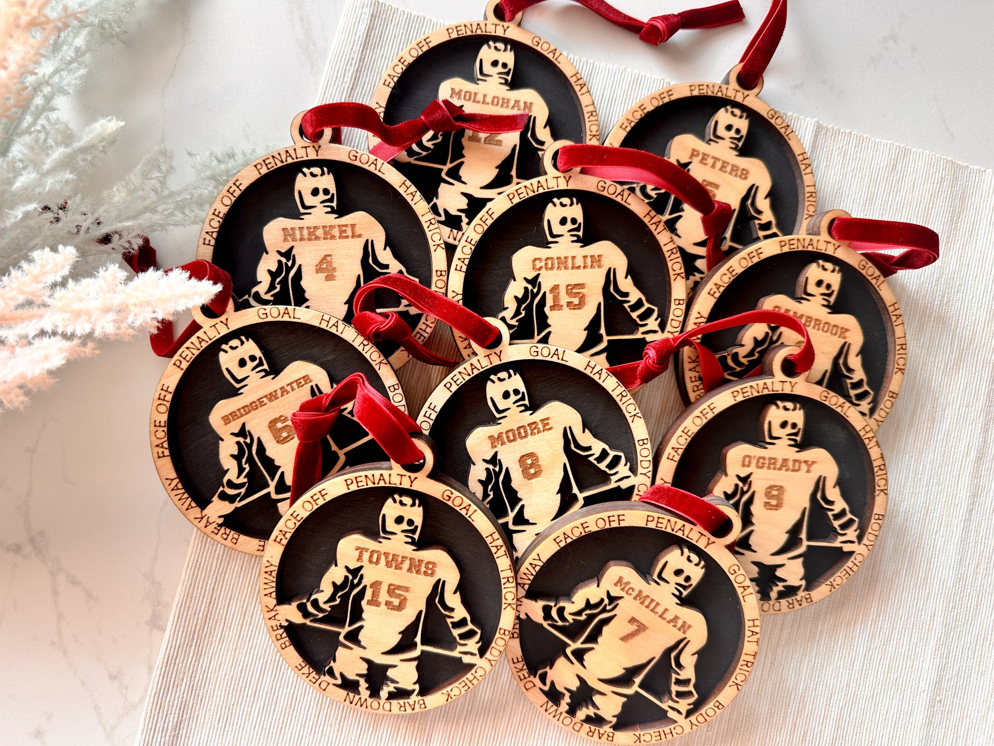 Commemorative ornaments featuring players last name and jersey number. The border features hockey related verbiage.