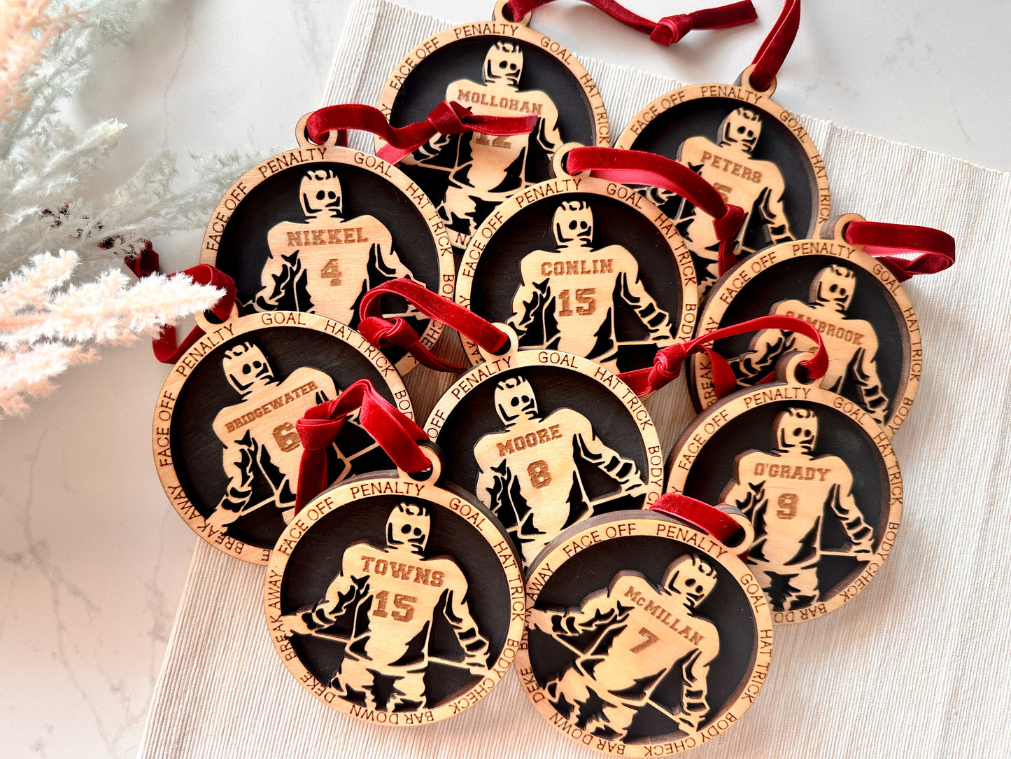 Commemorative ornaments featuring players last name and jersey number. The border features hockey related verbiage. 