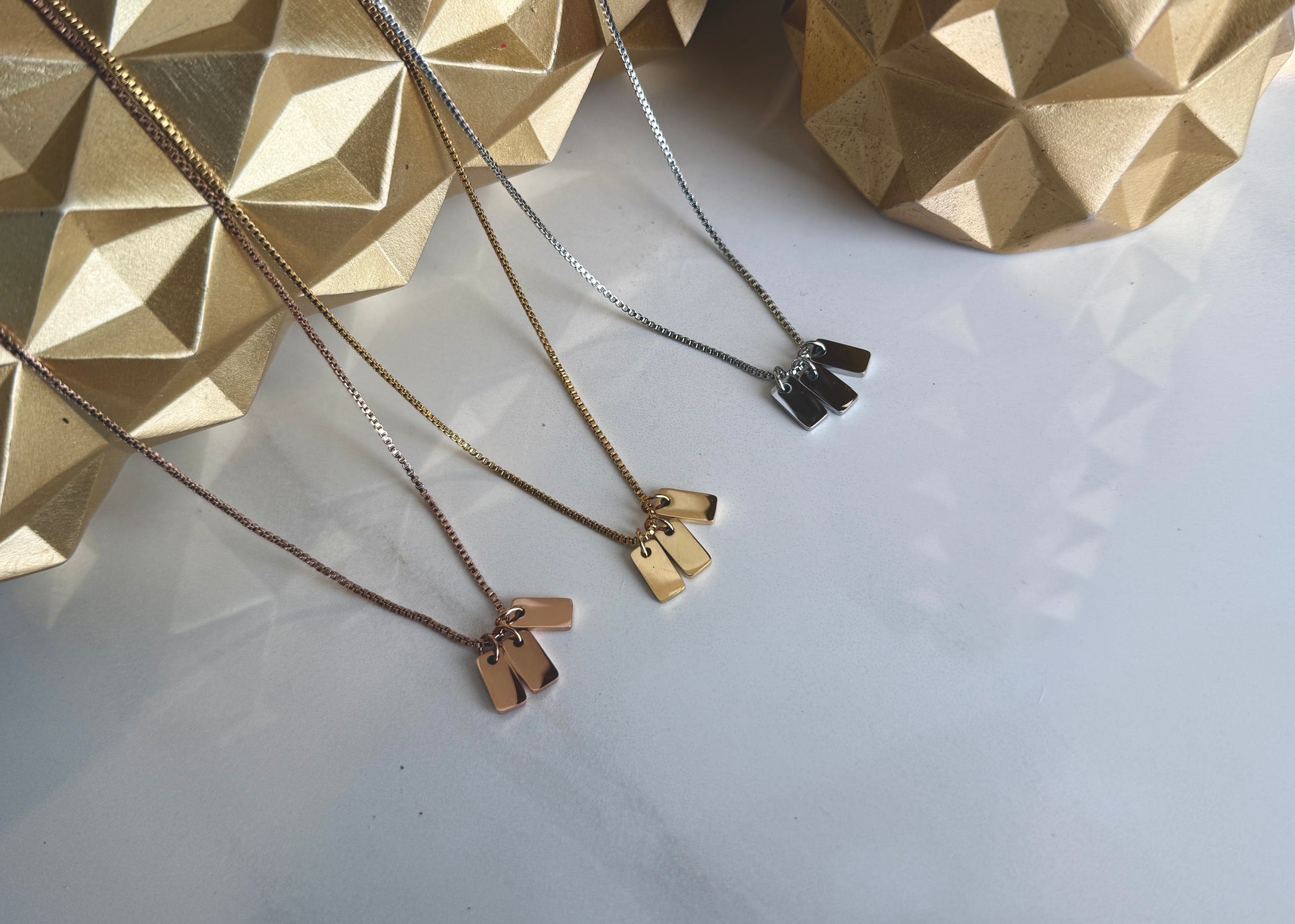 Rose gold, gold and silver coloured necklaces on a white background